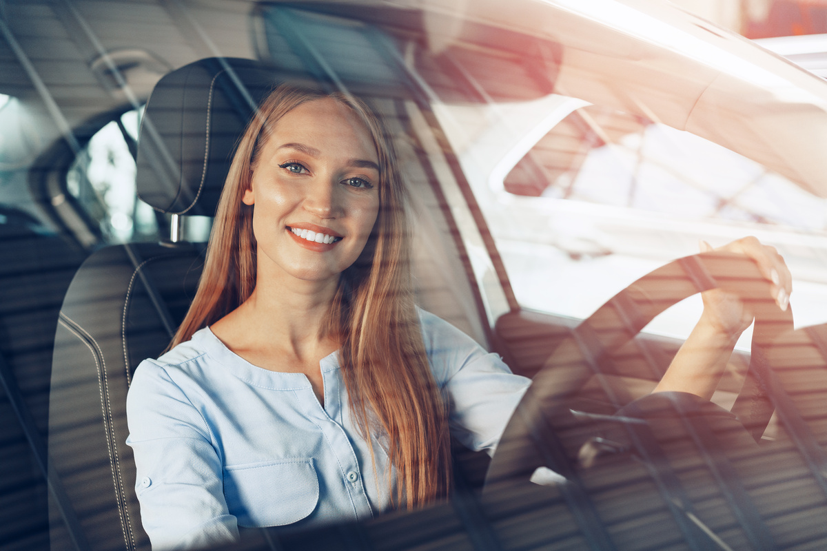 Jeune femme au volant de sa première voiture