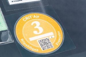 Duplicata de vignette Crit'Air 3 orange collée sur le pare-brise d'un véhicule