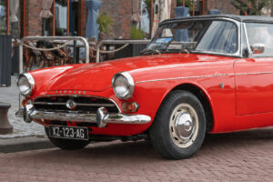 Cabriolet ancien rouge avec plaque noire SIV illustrant les avantages de la carte grise collection en 2026.