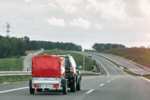 Véhicule tractant une remorque bâchée sur une voie rapide, illustrant la réglementation pour immatriculer une remorque en 2026.