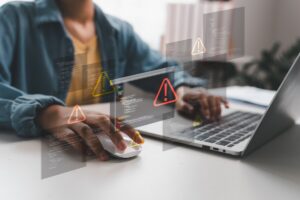 Un utilisateur face à un écran d'ordinateur affichant des alertes de sécurité suite à la cyberattaque ANTS.
