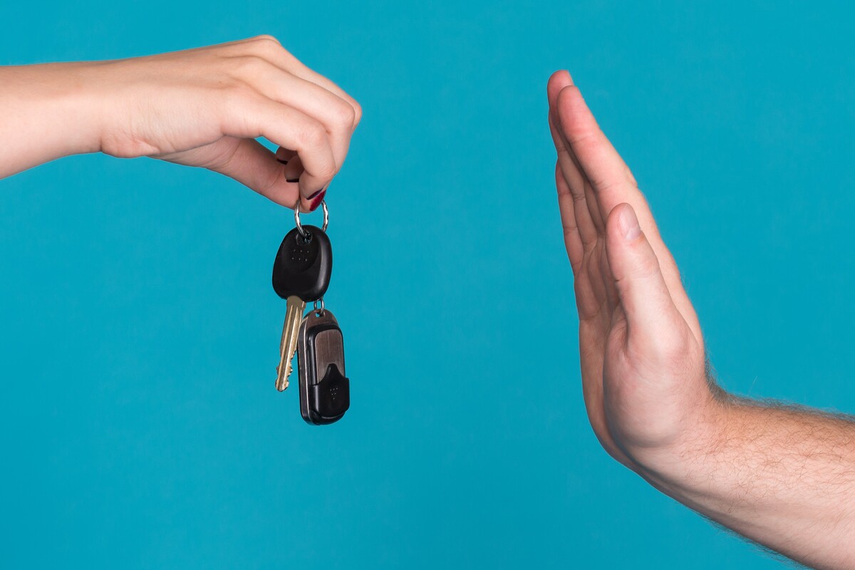 Une main refusant des clés de voiture pour illustrer un recours pour certificat de non-gage bloqué.