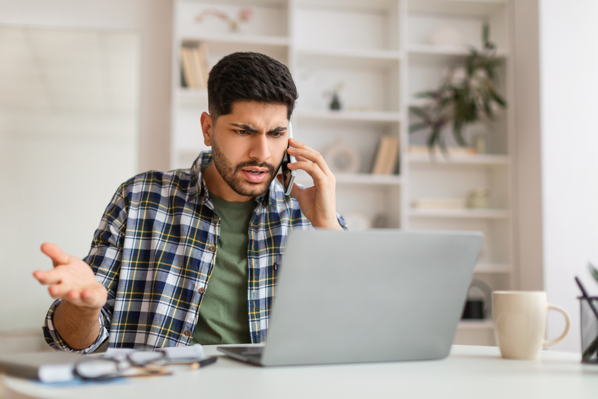 Homme frustré face à son ordinateur pour un dossier carte grise rejeté