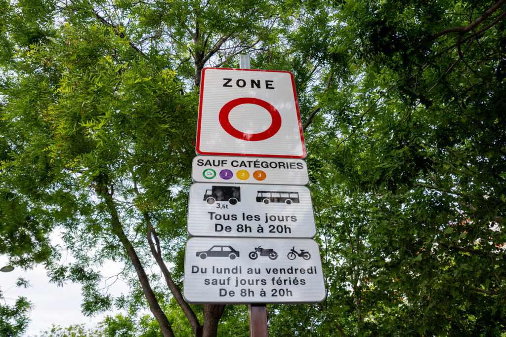 Panneau routier officiel de Zone à Faibles Émissions (ZFE) informant les conducteurs sur ZFE et vacances ainsi que les restrictions Crit'Air applicables.