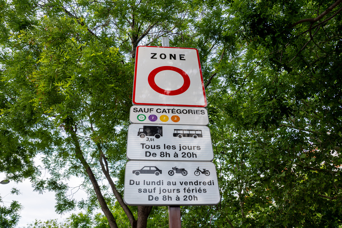 Panneau routier officiel de Zone à Faibles Émissions (ZFE) informant les conducteurs sur ZFE et vacances ainsi que les restrictions Crit'Air applicables.