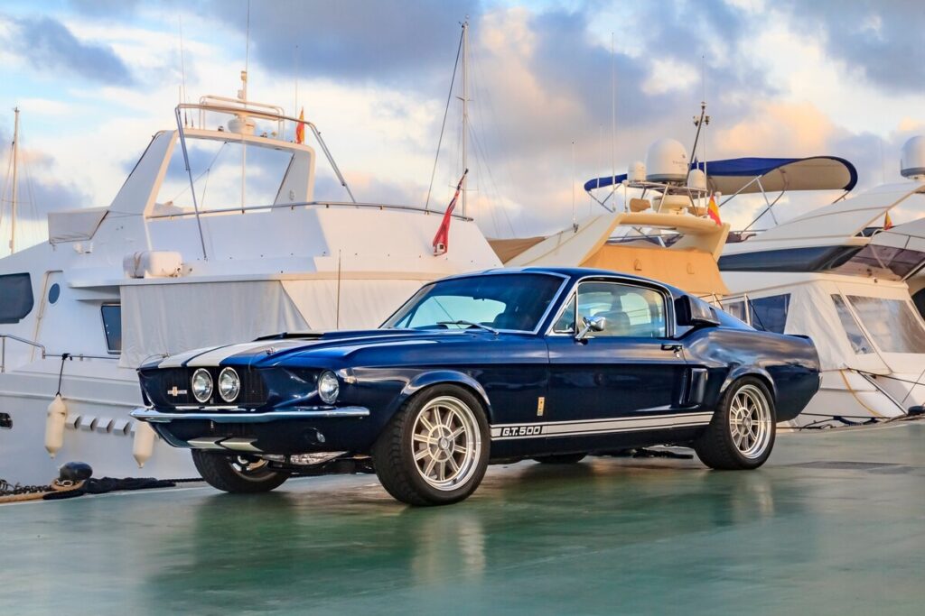 Voiture de collection importée Ford Shelby Mustang GT500 bleue stationnée sur un quai portuaire
