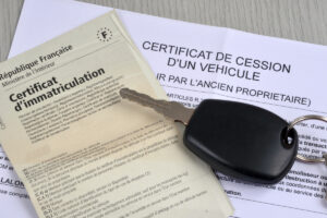 Carte grise barrée et certificat de cession aux côtés de clés de voiture